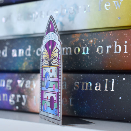 Decorative stainless steel standee with 'Science Fiction' design on in the style of a stained glass window at an angle to see it is an L shape with a stack of books behind.
