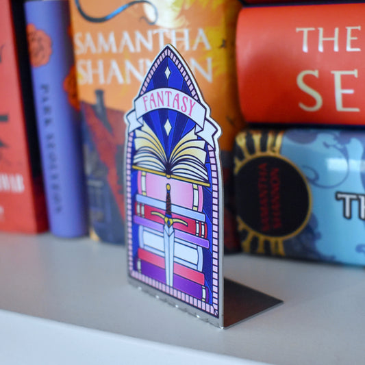 Decorative stainless steel standee with 'Fantasy' design on in the style of a stained glass window at an angle to see it is an L shape with a stack of books behind.