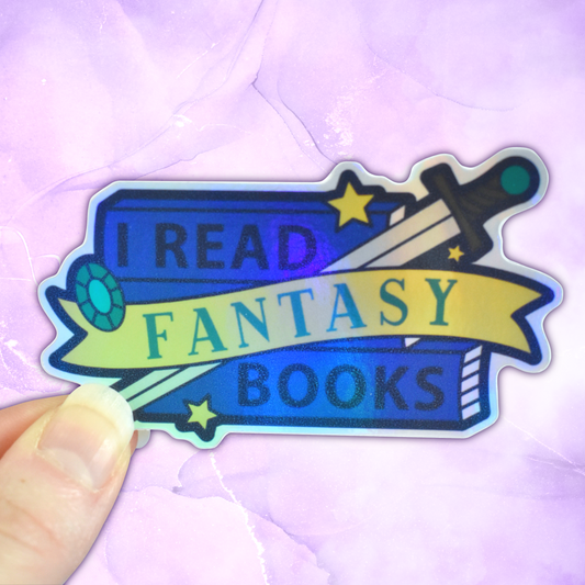 Bookish holographic sticker with 'I read fantasy books' text on a banner, on top of a stack of blue books with a sword, gem and star details, held by a white hand against a pastel purple background