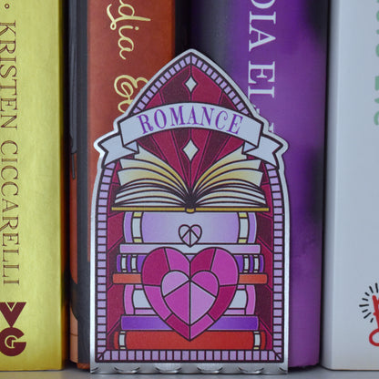 Decorative stainless steel standee with 'Romance' design on in the style of a stained glass window pushed up against a row of books.