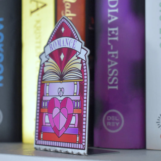 Decorative stainless steel standee with 'Romance' design on in the style of a stained glass window at an angle to see it is an L shape with a row of books behind.