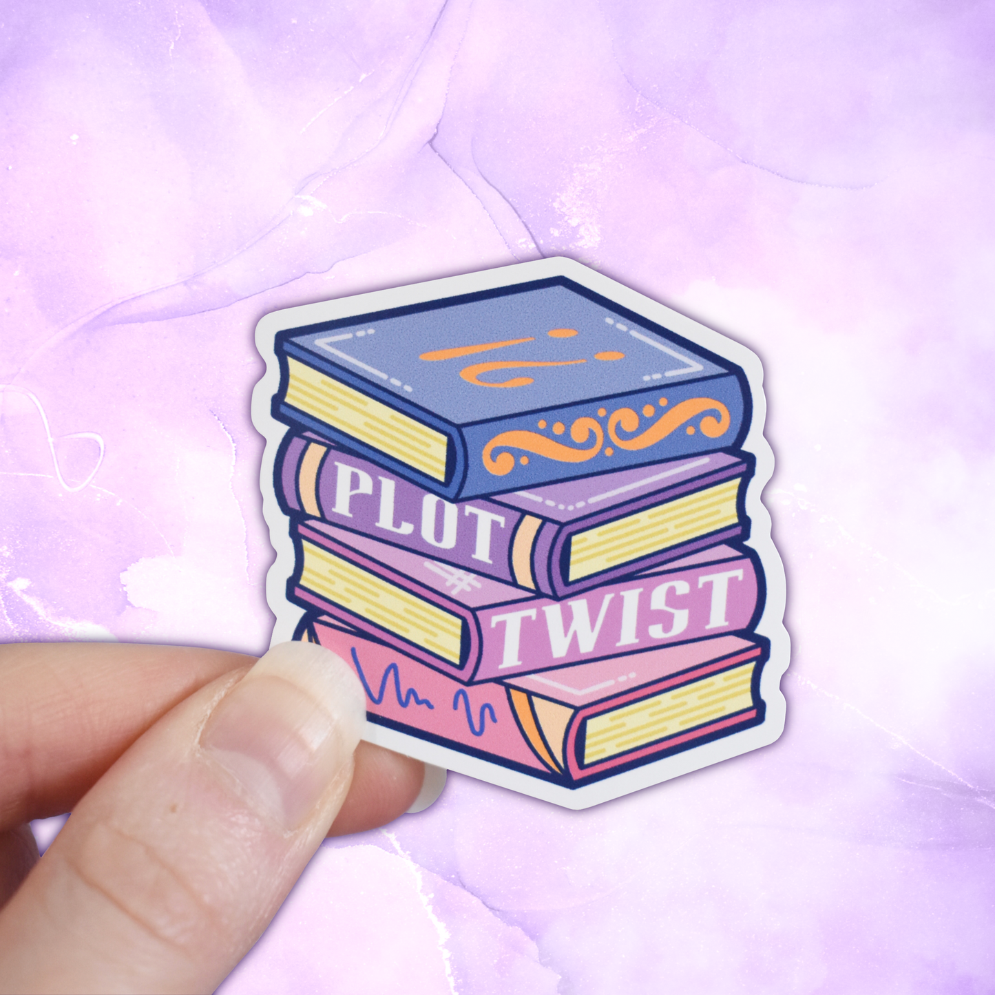 Bookish mini sticker of a stack of books in blues, purples and pinks with 'Plot Twist' text. Held by a white hand on a pastel purple background.
